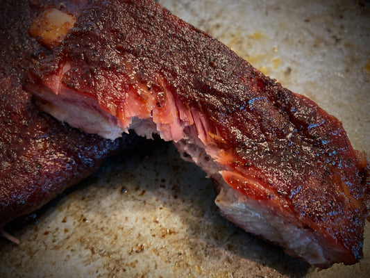 Close-up of smoked ribs on a rustic surface