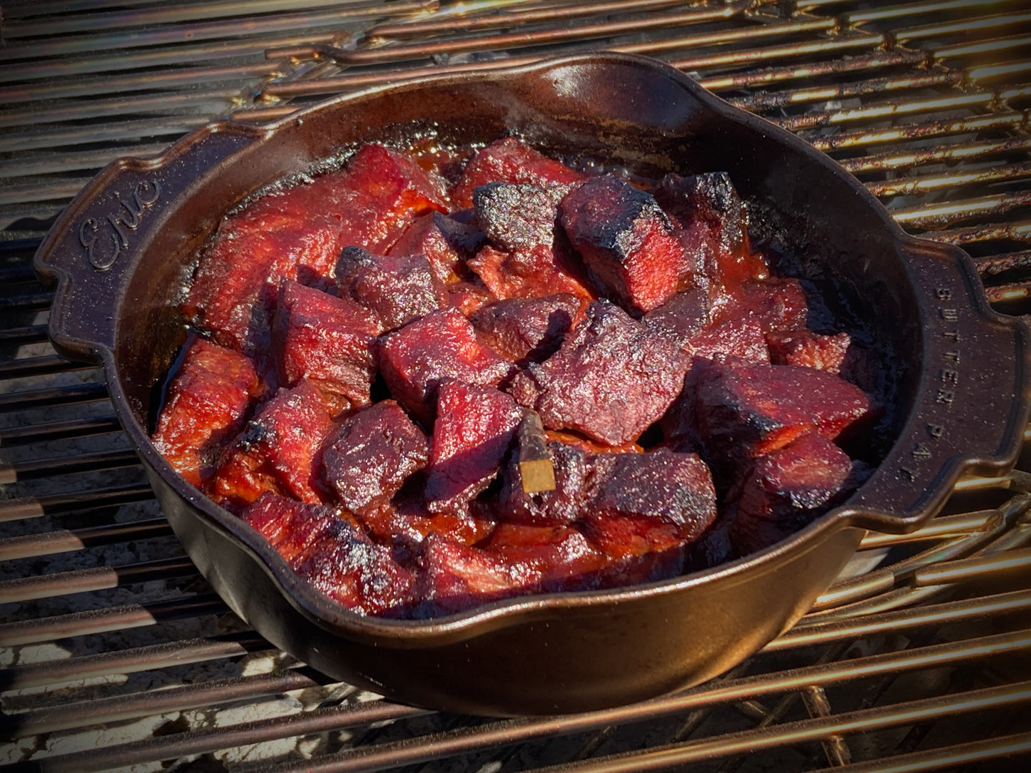 Brisket burnt ends in a cast iron skillet on a grill