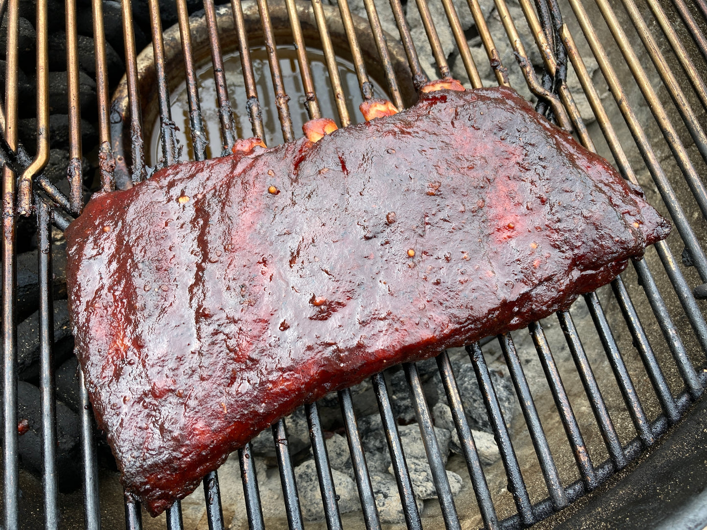 smoked ribs on a grill with a focus on the barked surface.