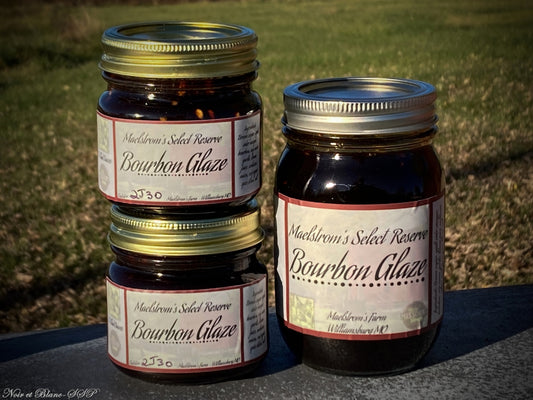 Three jars of Maelstrom's Select Reserve Bourbon Glaze on a stone surface with grass in the background.